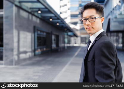 Businessman standing outdoors in city business district. Aimed to success in business