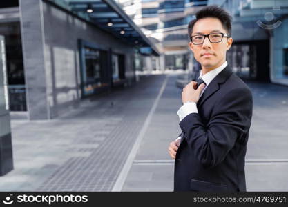 Businessman standing outdoors in city business district. Aimed to success in business