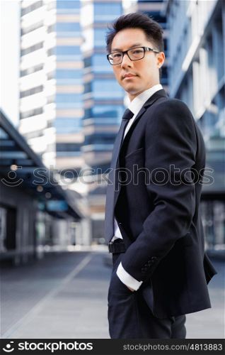 Businessman standing outdoors in city business district. Aimed to success in business