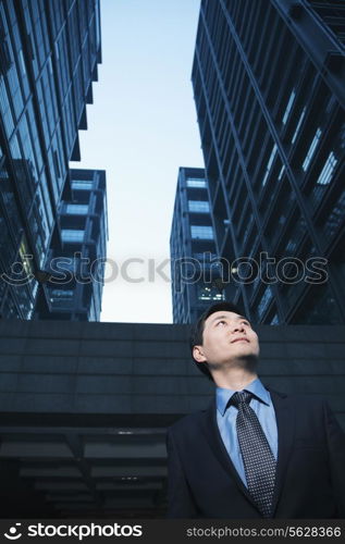 Businessman standing outdoors, low angle view, Beijing