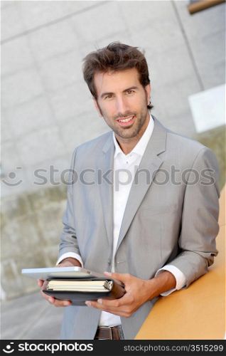 Businessman standing outside offices building