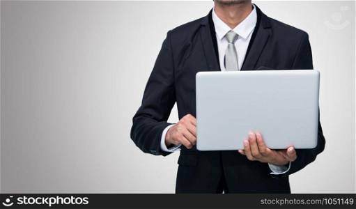 Businessman standing posture hand hold notebook laptop isolated on gray background