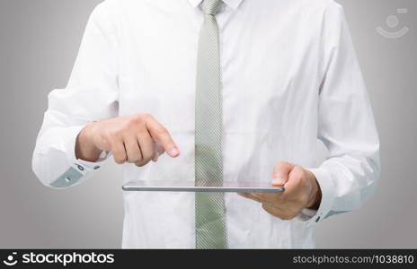 Businessman standing posture hand holding blank tablet isolated on over gray background