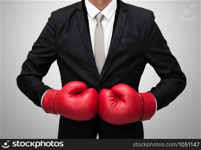 Businessman standing posture in boxing gloves isolated on over gray background