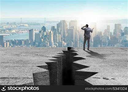 Businessman standing unsure next to cliff
