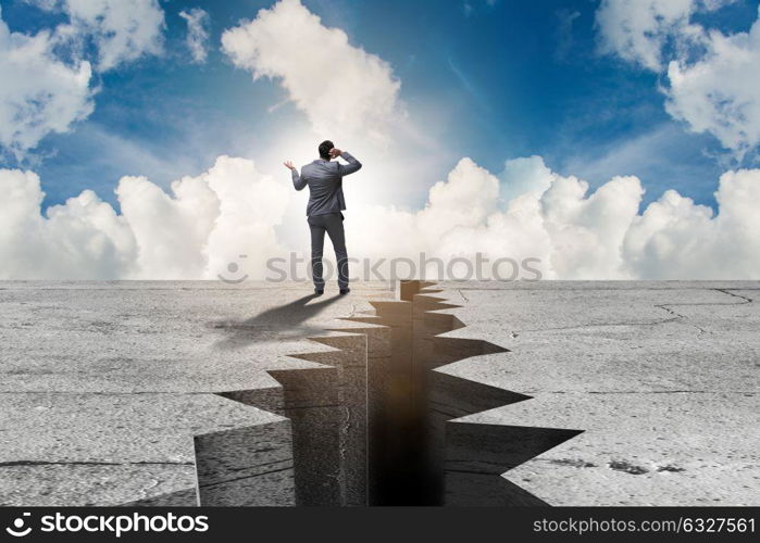 Businessman standing unsure next to cliff