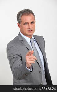 Businessman standing with finger pointed at camera