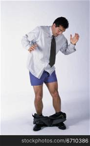 Businessman standing with his pants down