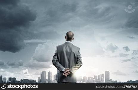 Businessman stands back and looks at flying objects. Making decision