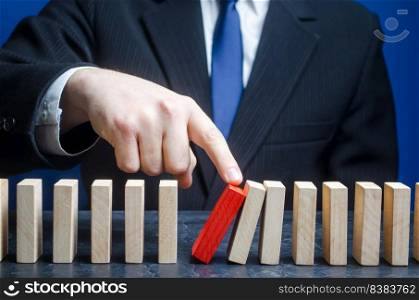 Businessman starts the process of falling dominoes. Starting work after stopping. Continuation of working, obstacle avoidance. maintainability. Correction of errors and malfunctions