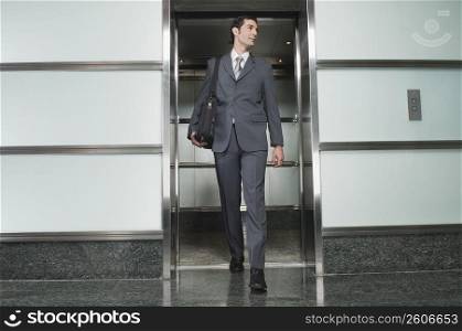 Businessman stepping out of an elevator