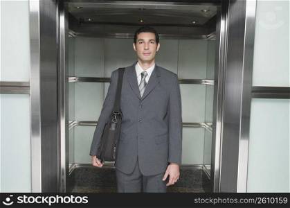 Businessman stepping out of an elevator