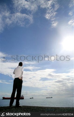 Businessman stood by river