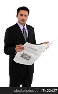 Businessman stood reading the daily newspaper