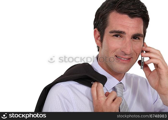Businessman stood with jacket over shoulder whilst making a call