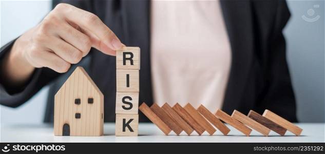 Businessman stop falling wooden blocks and protect house model. Crisis, fall Business, Risk, Economic recession, Developer, Real Estate and Property concept