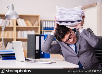 Businessman struggling with stacks of papers