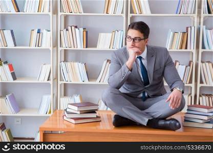 Businessman student in lotus position concentrating meditating . Businessman student in lotus position concentrating meditating in the library