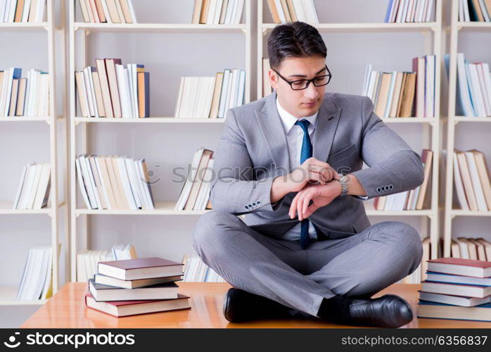 Businessman student in lotus position concentrating meditating . Businessman student in lotus position concentrating meditating in the library