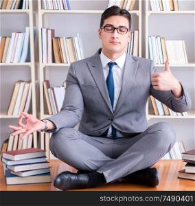 Businessman student in lotus position concentrating meditating in the library. Businessman student in lotus position concentrating meditating