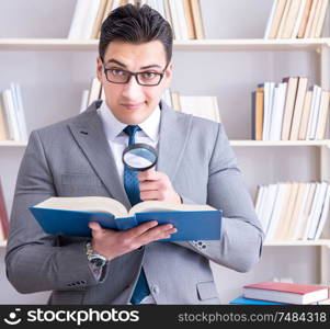 Businessman student reading a book studying in library. Business law student with magnifying glass reading a book