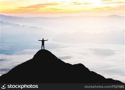 Businessman success raising arms stand on top of hill
