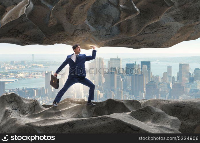 Businessman supporting stone under pressure