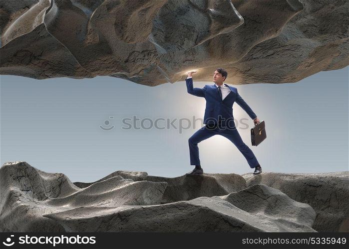 Businessman supporting stone under pressure