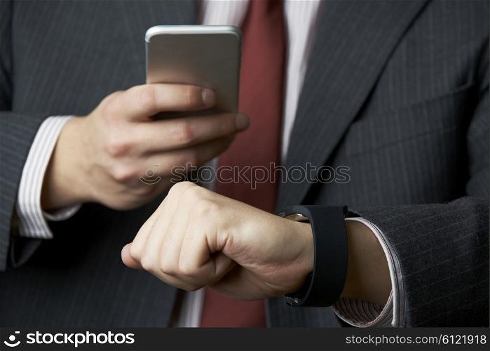 Businessman Synchronizing Smart Watch With Mobile Phone
