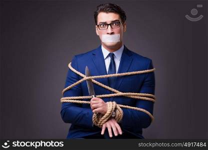 Businessman taken hostage and tied up with rope