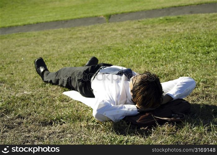 Businessman taking a nap in a park