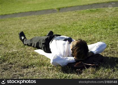 Businessman taking a nap in a park