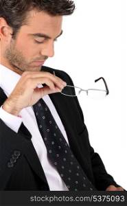 Businessman taking off his glasses