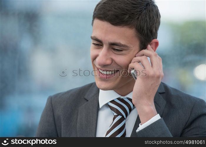 Businessman talking by mobile phone in urban surroundings