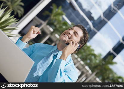 Businessman talking on a mobile phone and looking excited