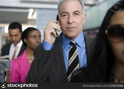 Businessman talking on a mobile phone at an airport