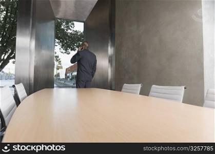 Businessman talking on a mobile phone in a board room