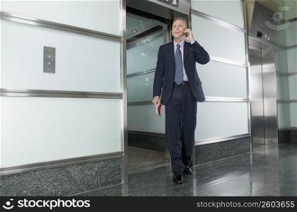 Businessman talking on a mobile phone in a corridor