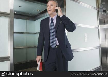 Businessman talking on a mobile phone in a corridor