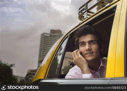 Businessman talking on a mobile phone in a taxi