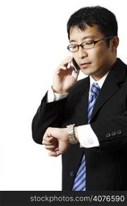 Businessman talking on a phone while watching his watch