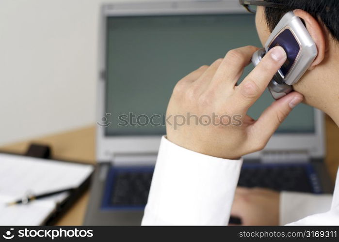 Businessman talking on cellphone at work