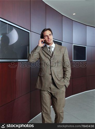 Businessman talking on mobile phone in office lobby