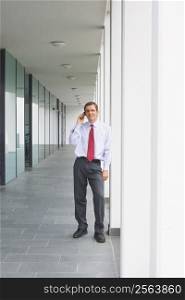 Businessman talking on mobile phone outside an office building