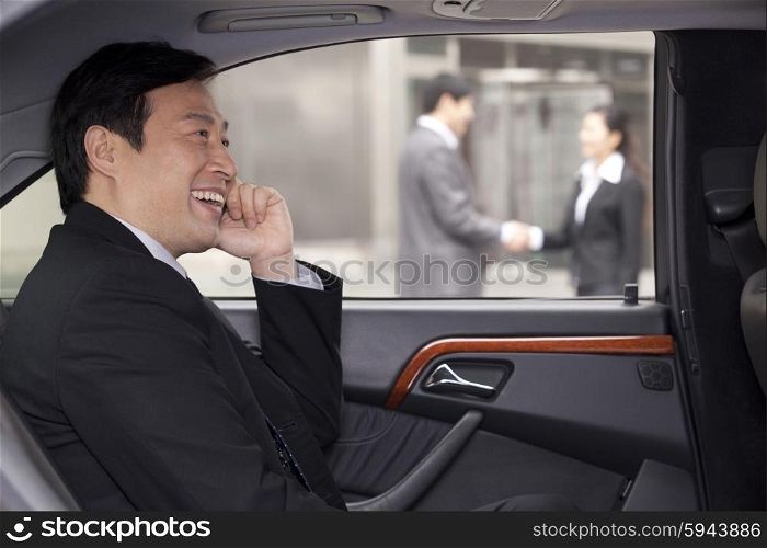 Businessman talking on phone in car