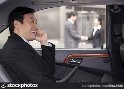 Businessman talking on phone in car