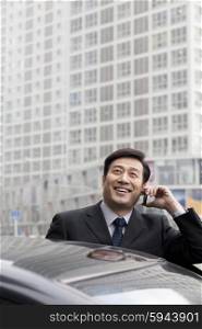 Businessman talking on phone outdoors