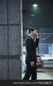 Businessman talking on the phone in a parking garage