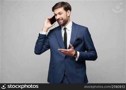 businessman talking on the phone isolated over grey background in studio shooting. businessman talking on the phone isolated over grey background