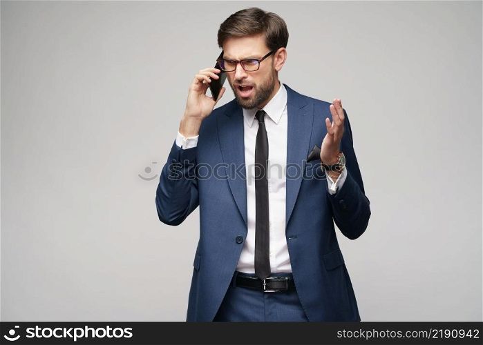 businessman talking on the phone isolated over grey background in studio shooting. businessman talking on the phone isolated over grey background